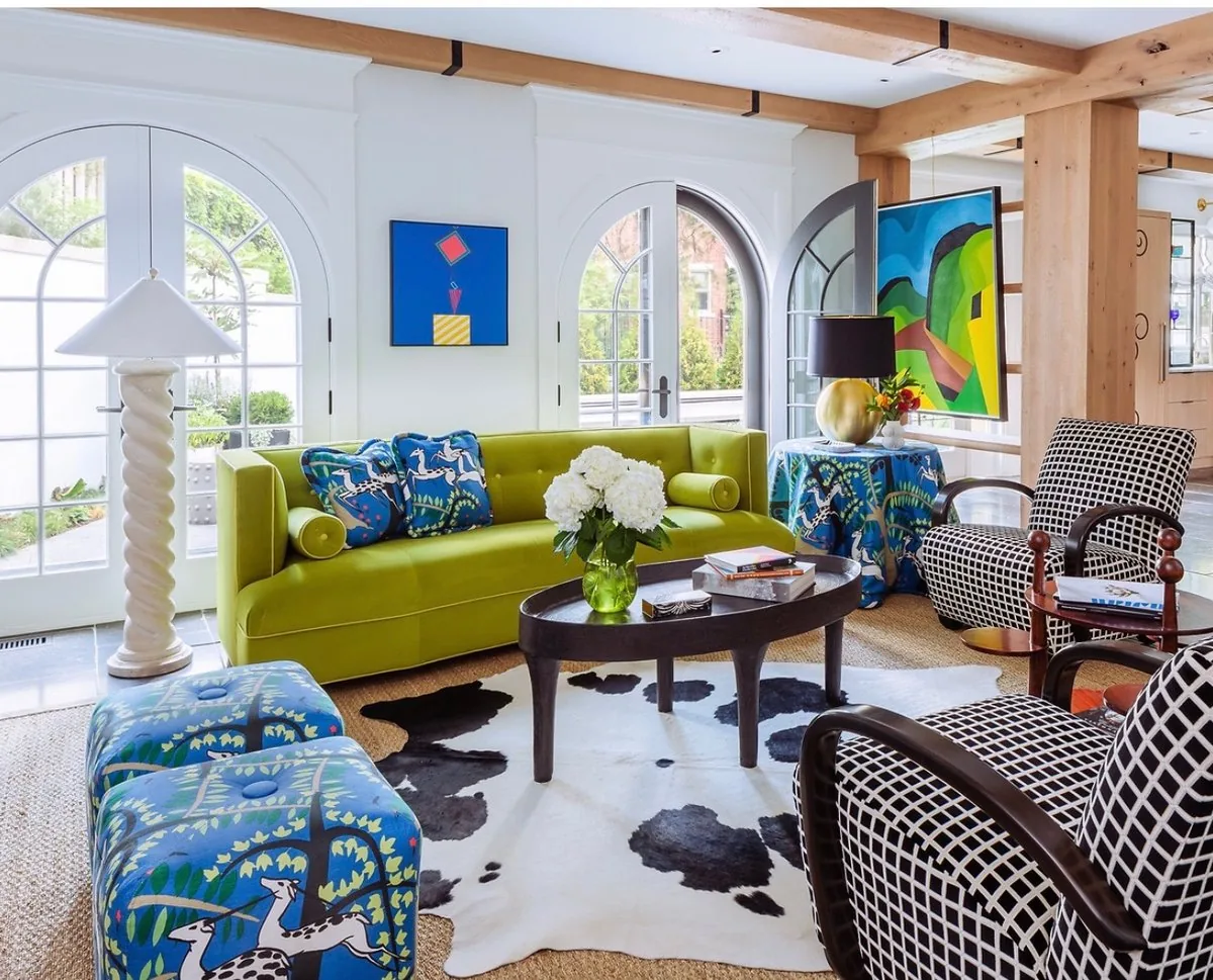 Happy Hollow family room, chartreuse tufted sofa, printed blue ottomans, grid chairs, bold abstract paintings, and arched French doors to the garden. Studio Eckström
