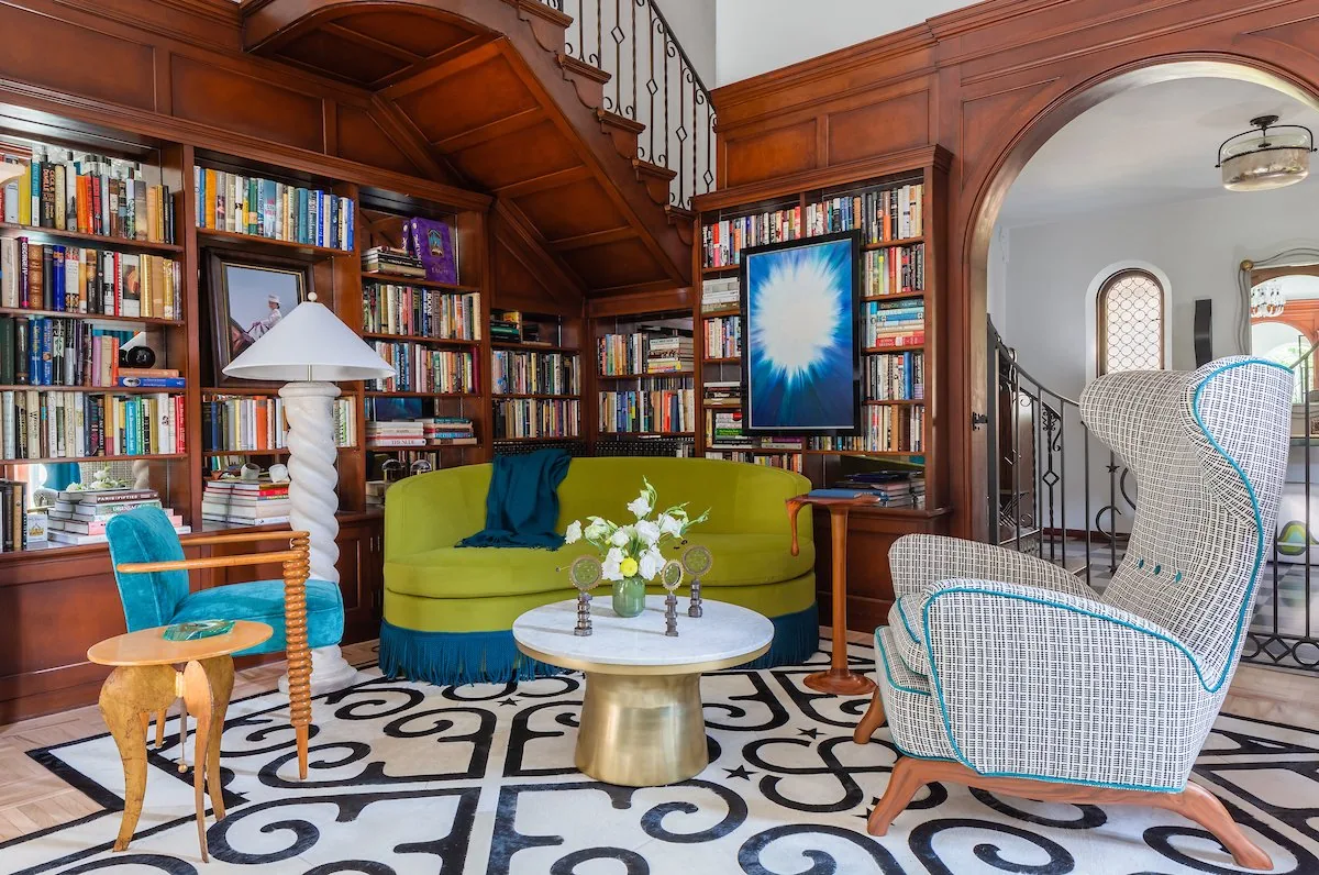 Happy Hollow salon, chartreuse tufted sofa, large abstract painting, Murano glass chandelier, and black and white scroll rug. Studio Eckström