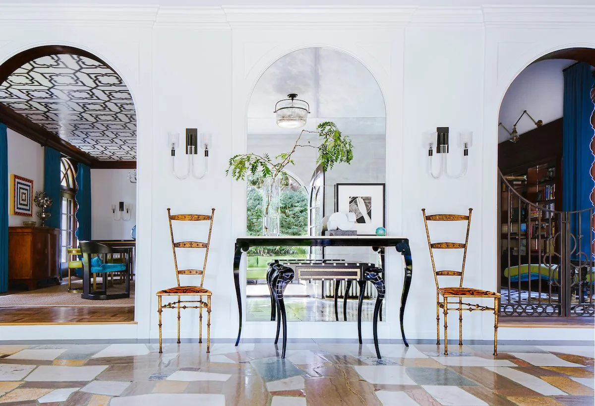 Happy Hollow sunroom, expansive stone patchwork floor, arched Gothic windows, and steel-framed glass partition in natural light. Studio Eckström