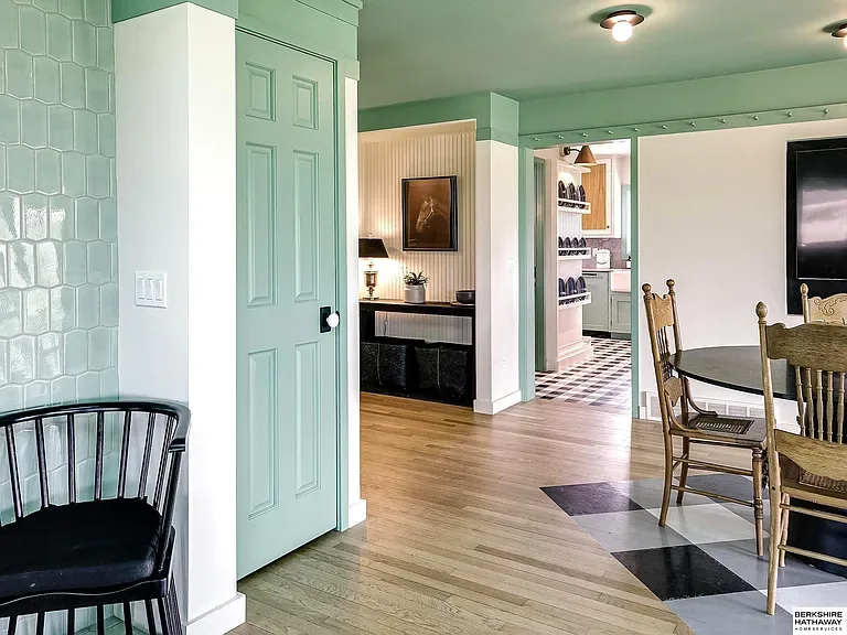 Entry hall with mint green hexagonal wall tile, white millwork, and black and white checkered floor through to the kitchen. Country Equestrian, Studio Eckström